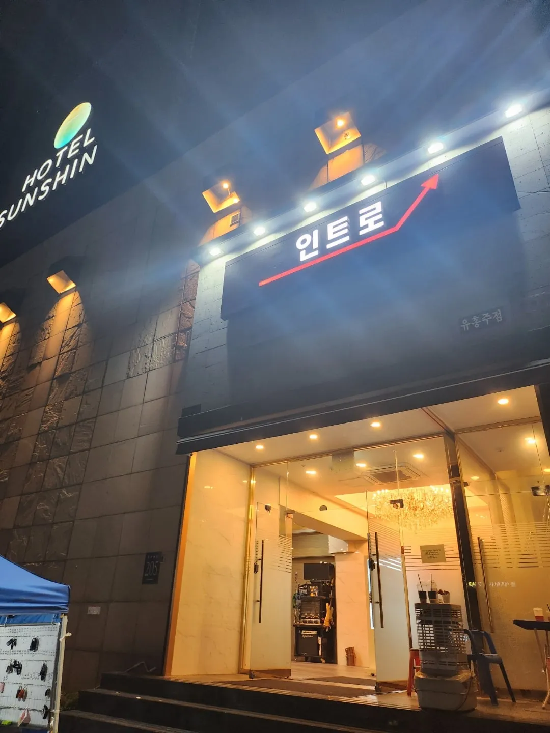 건물 외벽에 걸린 강남 인트로 간판과 입구를 밤에 촬영한 사진